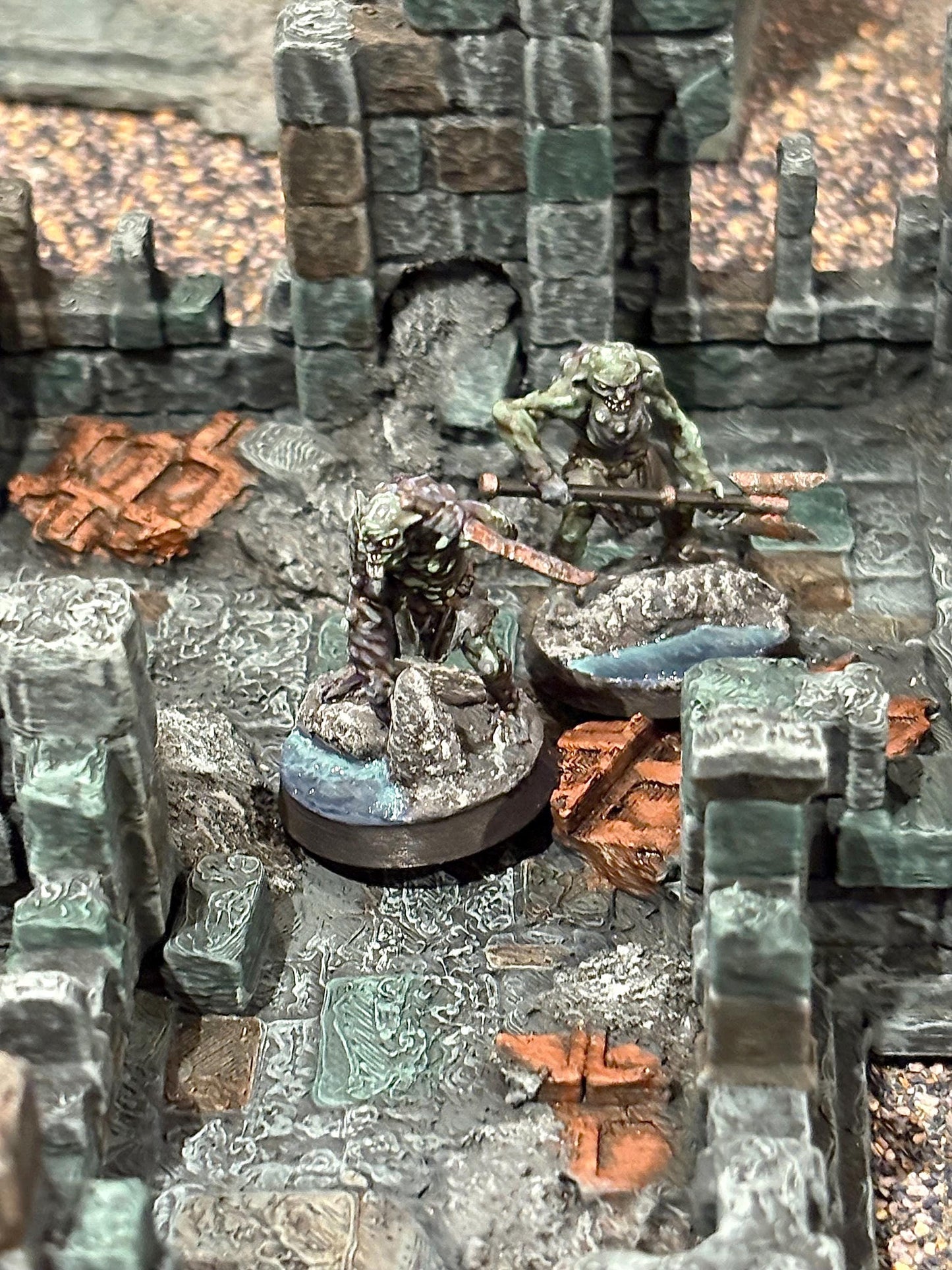 two Drekh warrior miniatures make their way through a ruin