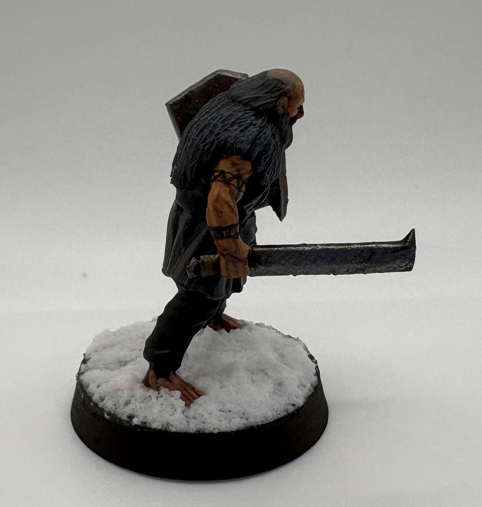 Miniature dark fantasy hillmen figurine of a character with a long beard and a large axe on a white background