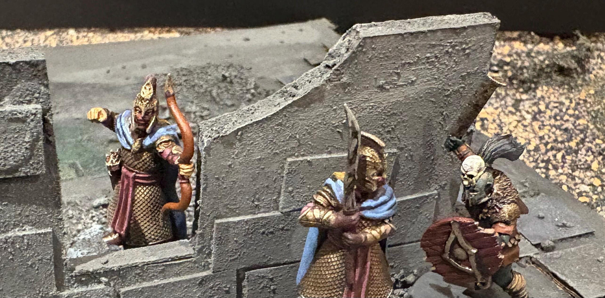 3D printed dark fantasy elf miniatures face off against an orc warrior during a tabletop skirmish game